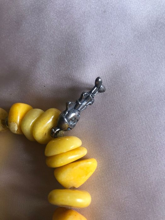 Pulseira com pedras amarelas e elementos metálicos como a estrela e outros
