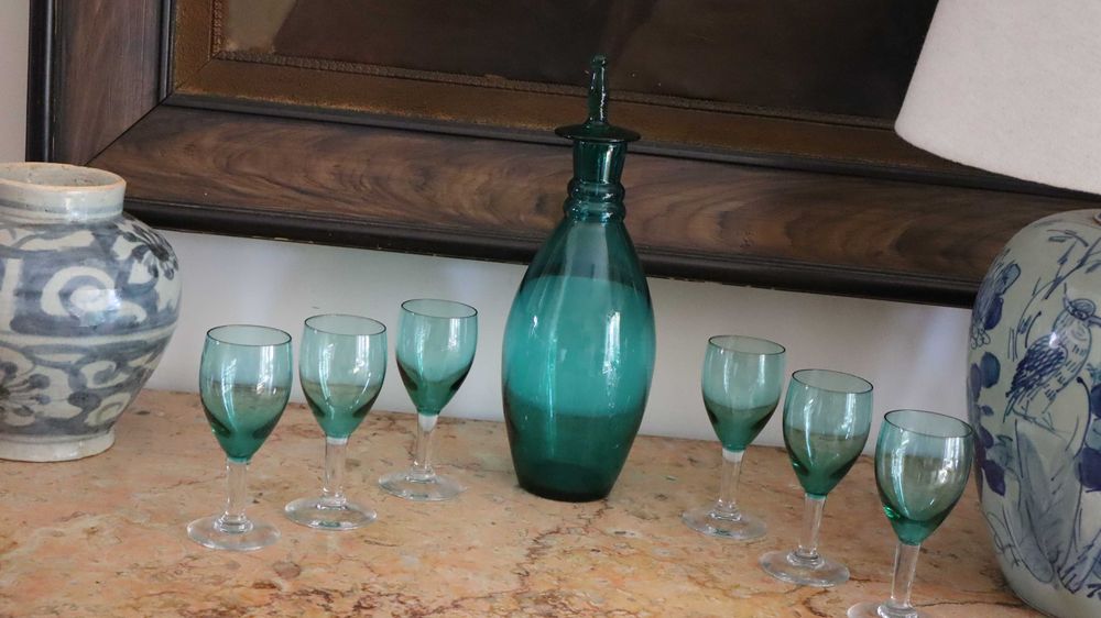 Garrafa e copos de pé alto em vidro de cor verde