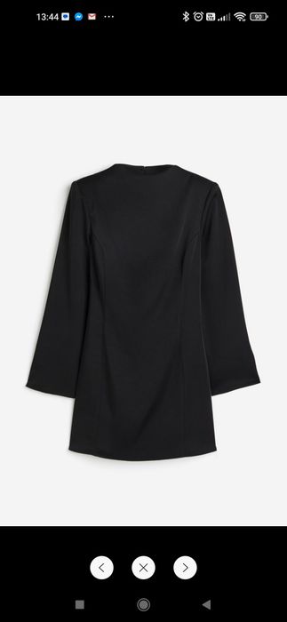 Czarna krótka sukienka z poduszkamin na ramionach i wycięciem z tyłu