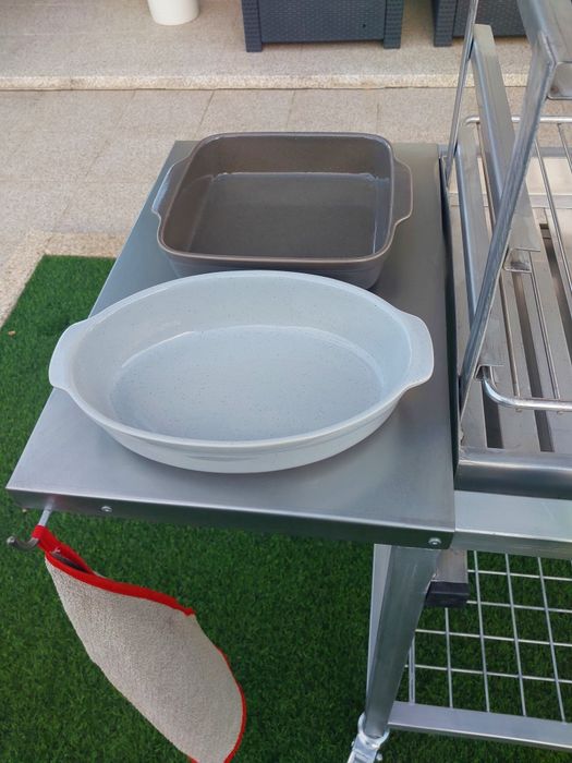 Churrasqueira com rodas, tem queimador  e grelha em inox  duas mesas de apoio uma em inox outra em nylon  e plataforma para lenha..