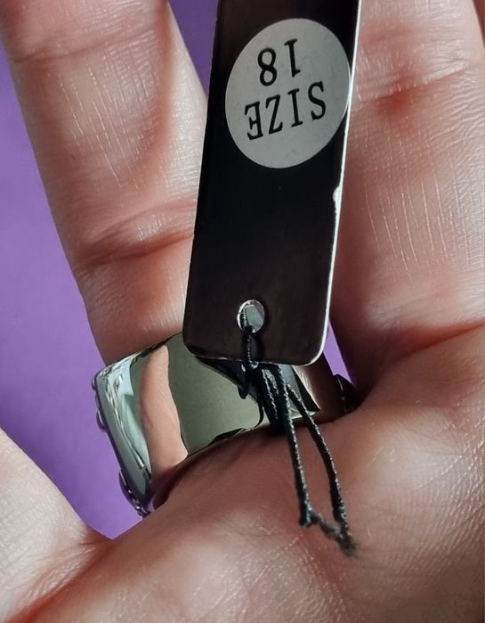 Anel prateado, em aço, aberto dos lados e cheio de zirconias. T17/18