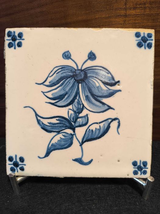 Azulejo antigo, em tons de azul, motivo plantas. Alguns sinais de uso.
