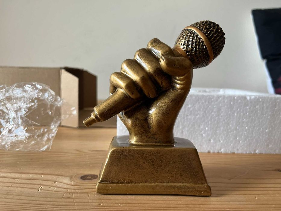 Trofeu mão com microfone dourado