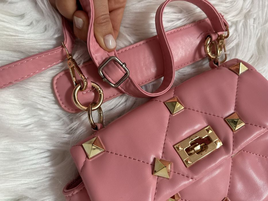 Mala cor de rosa com tachas