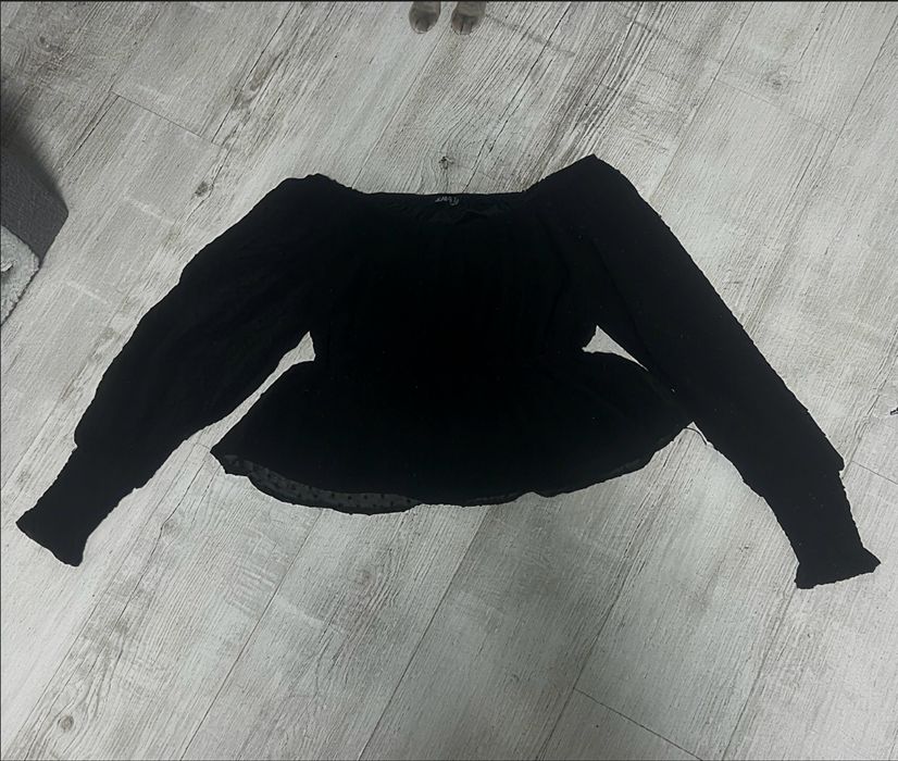 Чорна шифонова блуза з відкритими плечима та об’ємними рукавами.