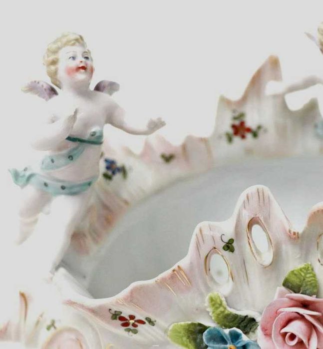 Taça em porcelana modelada em forma de búzio com querubins e flores