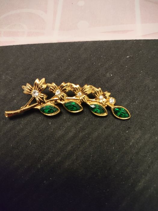 Брошка за зеленими камінчиками.