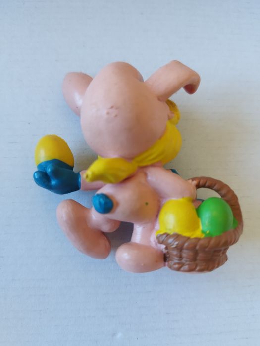 Smurfina vestida de coelhinha cor-de-rosa com um cesto e um ovo de Pás