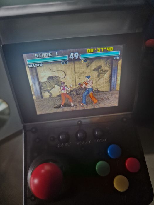 consola portátil retro a correr o jogo Tekken Advance.