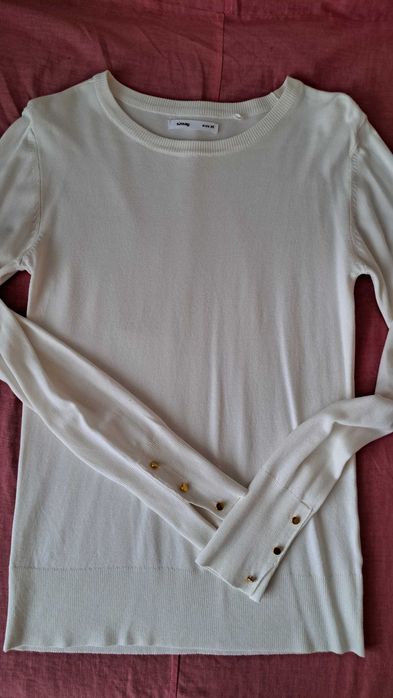 sweter w kolorze mlecznym.