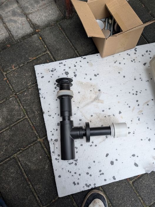 Umywalka z czarną baterią i syfonem