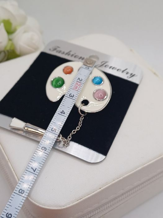 Ozdobna broszka paleta kolorów i pędzel