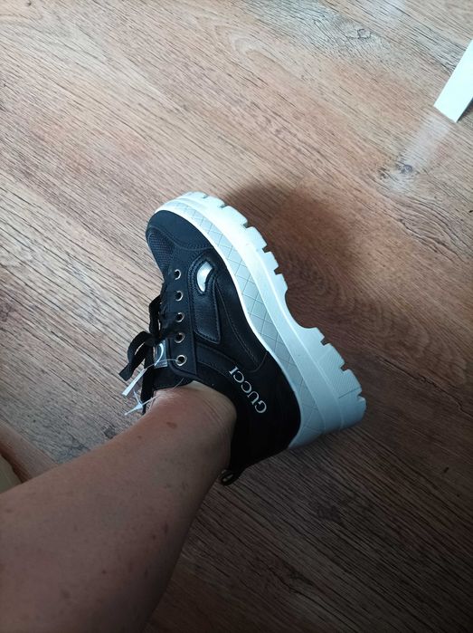 Buty sportowe sneakersy damskie czarne na białej podeszwie.