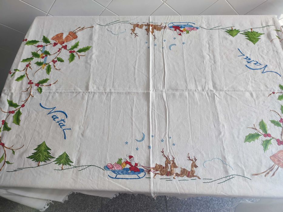 Toalha de natal branca com bordados natalícios.