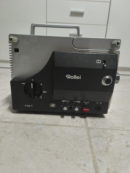 É um Rollei P84 T, um clássico projetor de filmes Super 8 com som, lançado na Alemanha entre 1971 e 1972