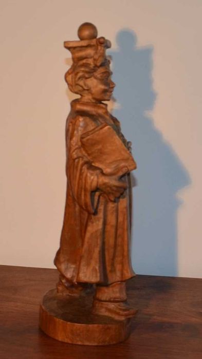 Estatueta esculpida em madeira maciça, representando um estudante universitário