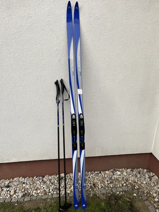 Zestaw narty biegowe, kijki, buty i pokrowiec.