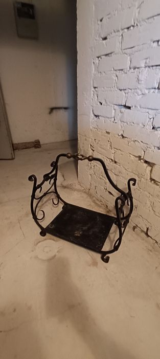 Żeliwny kosz na drewno kominkowe.