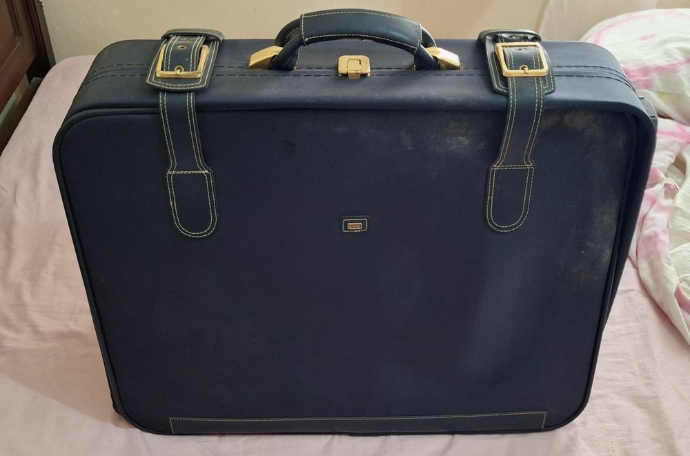 Mala de viagem azul com detalhes dourados