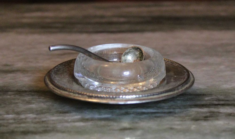 Saleiro de cristal com prato e pequena colher em casquinha, marcado.