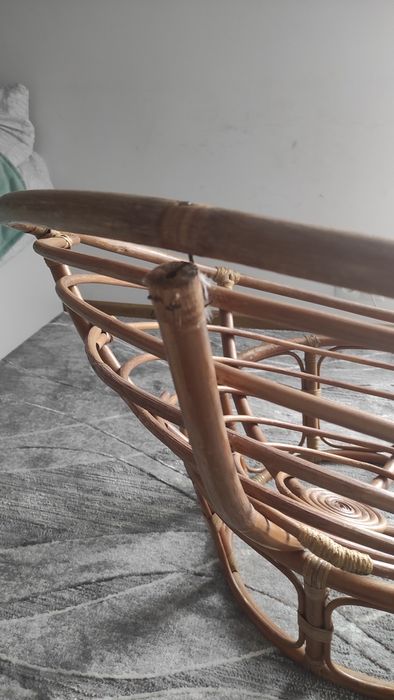 Duży fotel wiklinowy z poduszką.