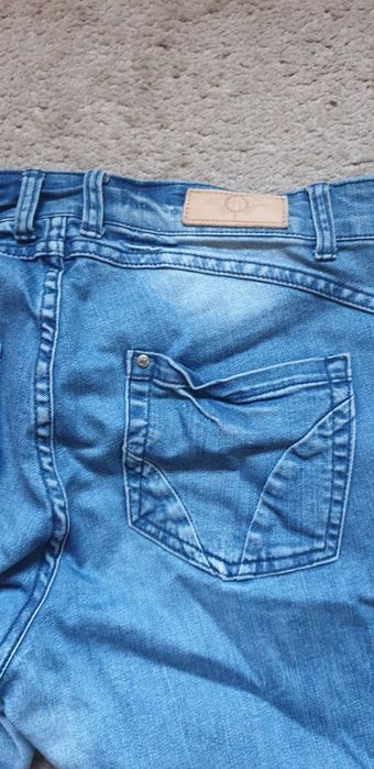 Spodnie jeansy z przetarciami.