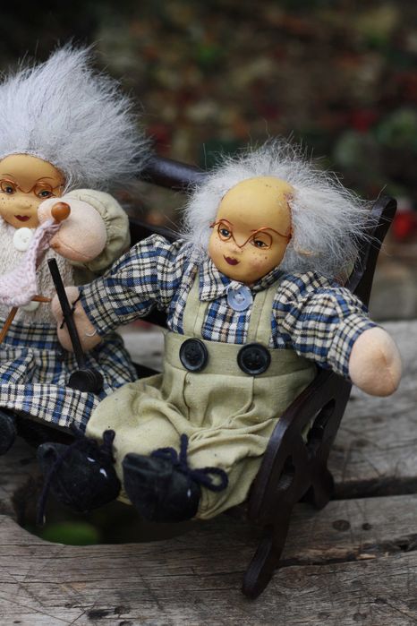 Dwie lalki siedzące na ławce Babcia i Dziadek