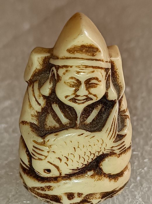 Antigo netsuke homem velho com peixe