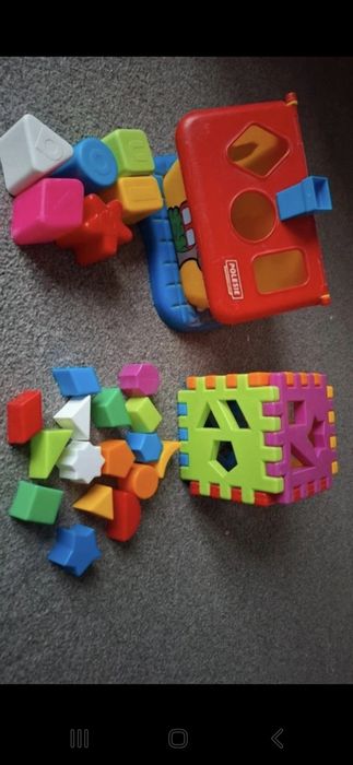 Dwie zabawki domek i kostka z klockami kształty