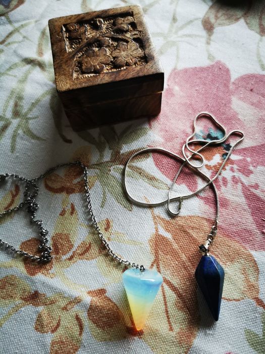 Dois pêndulos, lápis lazuli e pedra da lua, com caixa de madeira.