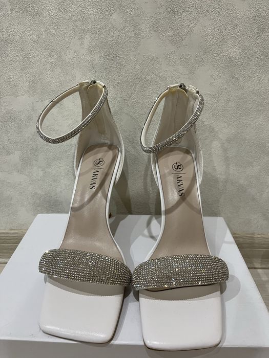 Білі босоніжки з камінцями.