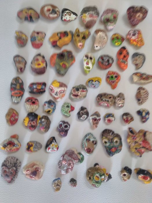 Pedras pintadas à mão com caricaturas variadas