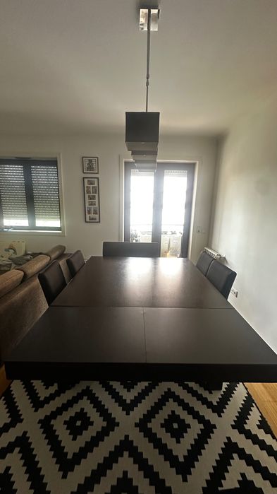 Mesa extensível castanha escura Interdesign  com 8 cadeiras cremes de pele pêssego.