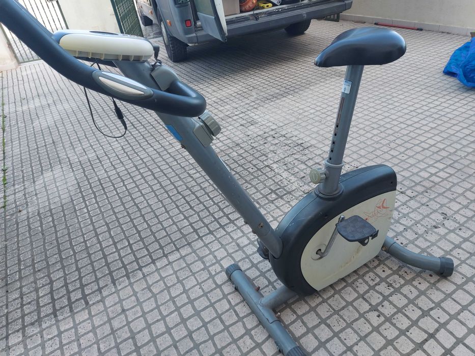 Bicicleta estática de ginástica, cinzenta e preta
