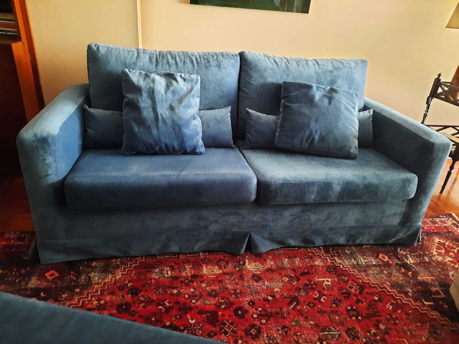 Sofá e banqueta em veludo azul.