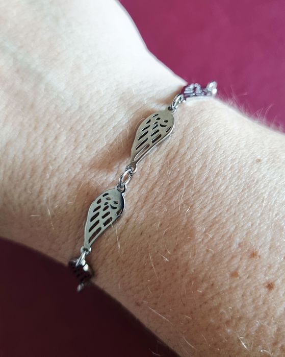 Conjunto prateado (colar e pulseira), em aço,  com asas de anjo.