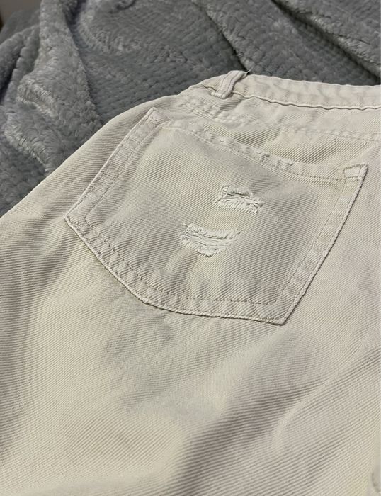 Kremowe mom jeans z przedarciami