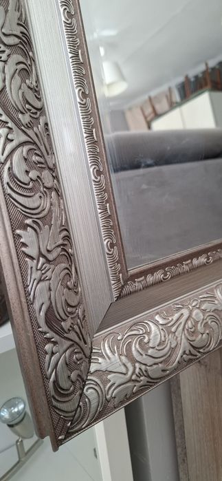 Lustro ścienne w eleganckiej szerokiej ramie