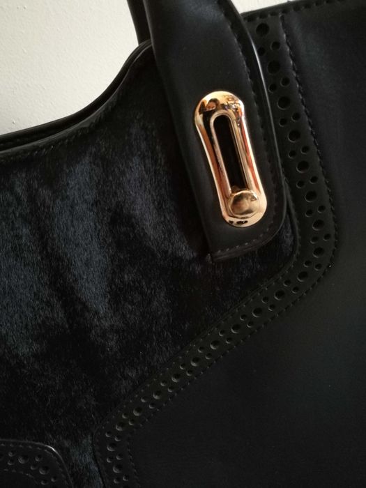 Mala preta elegante com pêlo curto e detalhes dourados