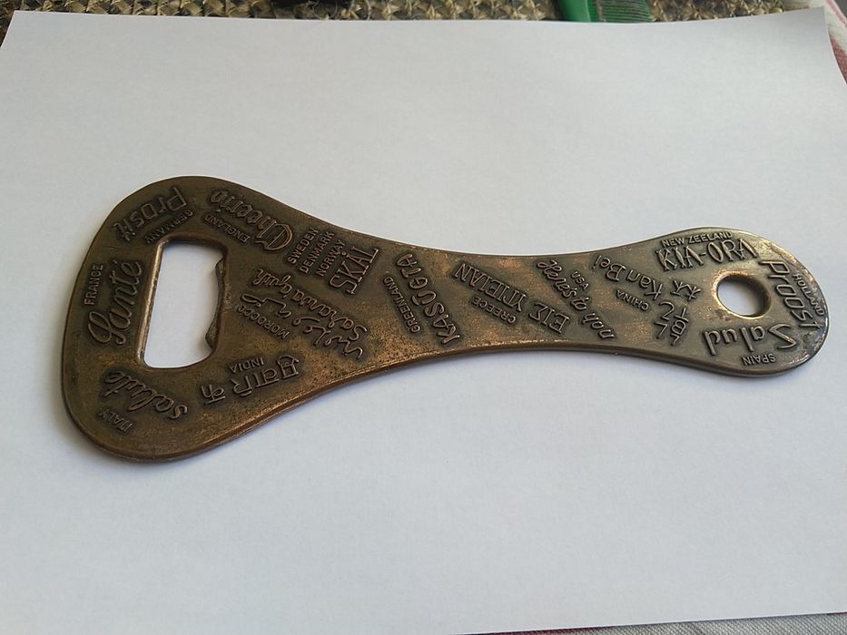 Duży mosiężny otwieracz do butelek.