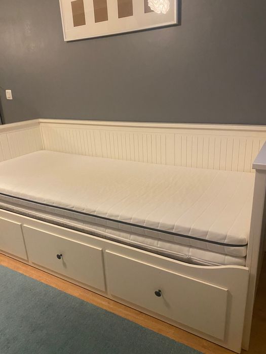 Um sofá, uma cama individual, uma cama de casal e arrumação