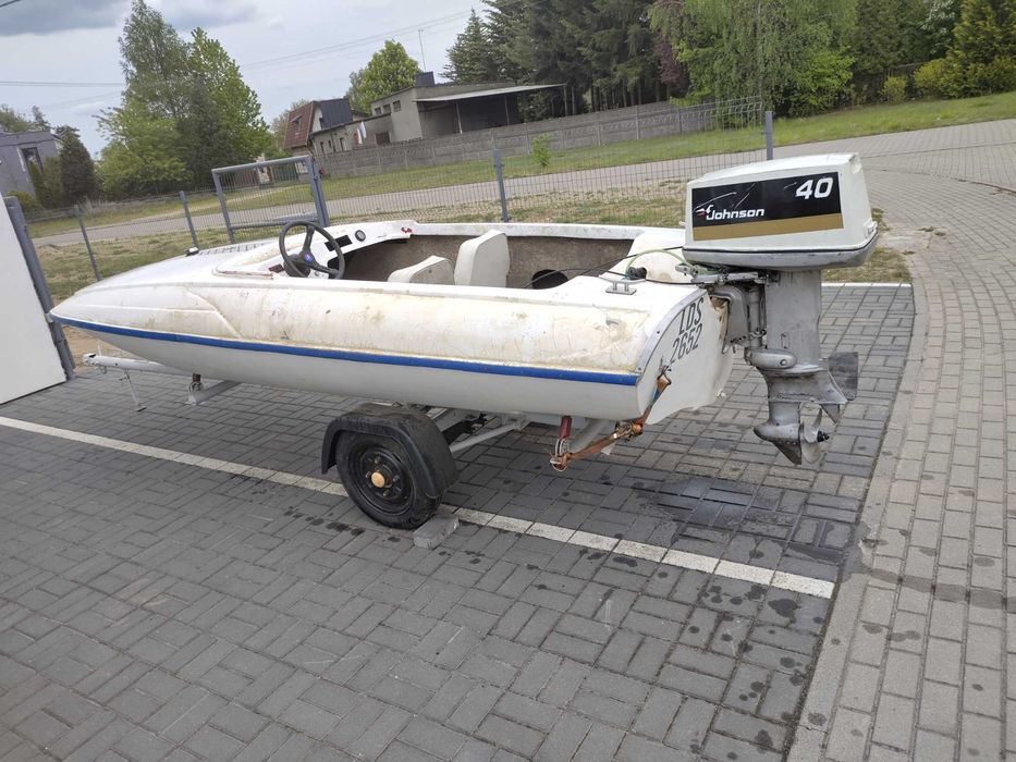 Łódź motorowa z przyczepą i śinkiem.