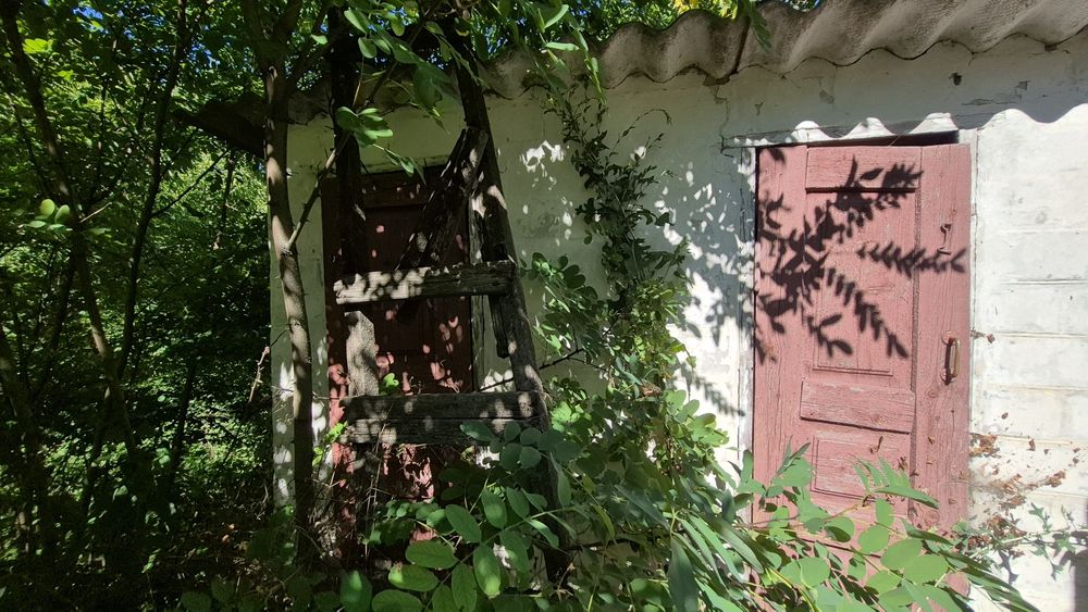 Будинок з джерельною водою на березі річки, асфальтована дорога