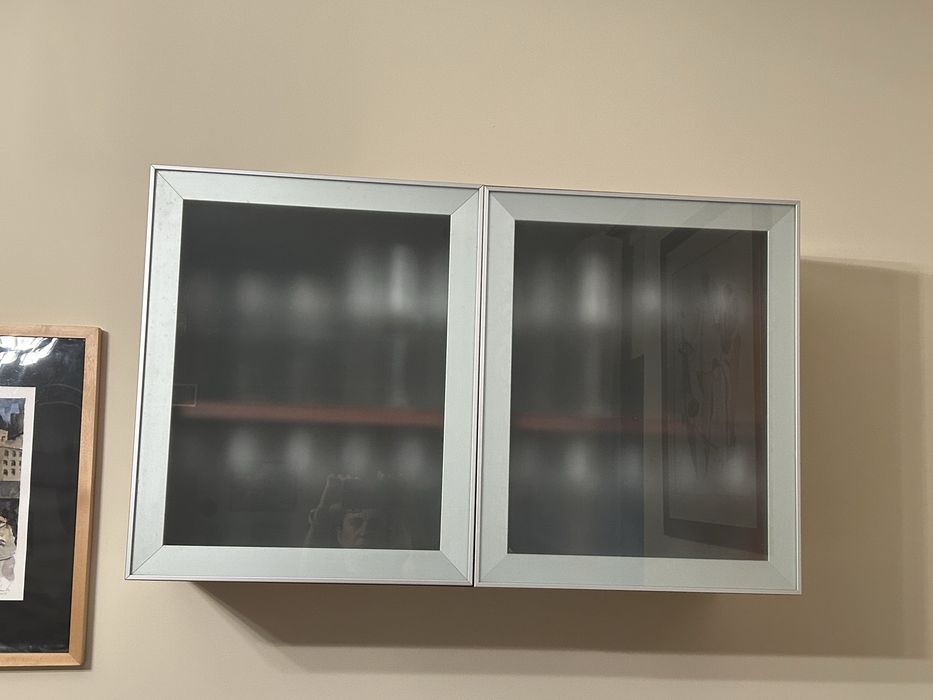 Movel suspenso em madeira, portas vidro fosco e moldura em metal.