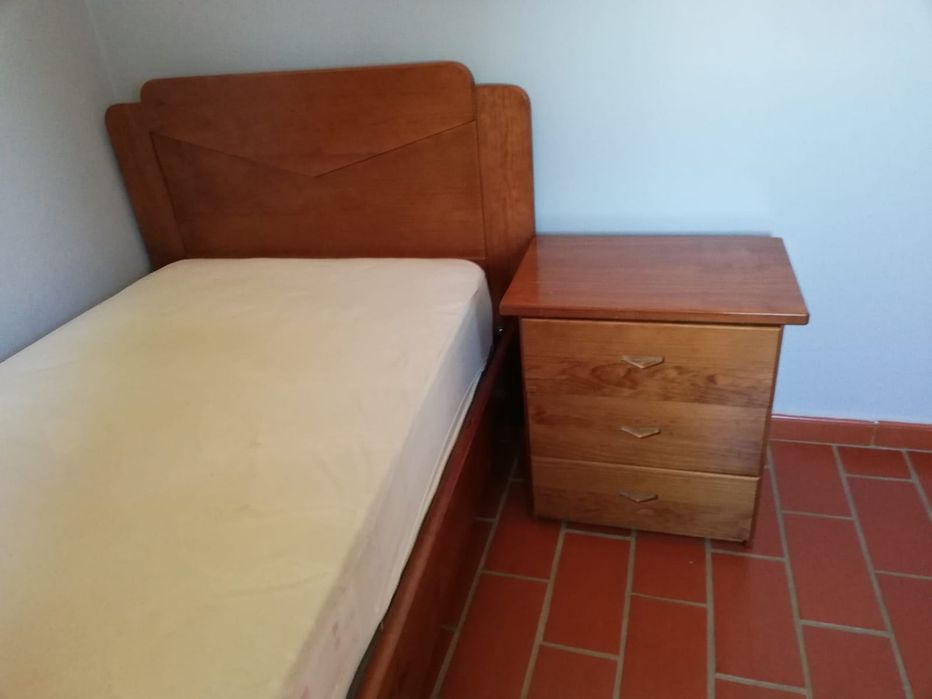 Cama com colchão e mesa de cabeceira