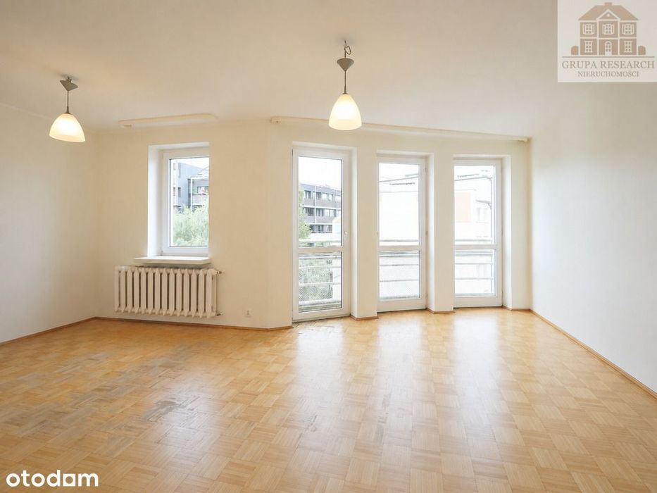 Jasny salon z dużymi przeszkleniami i garderobą