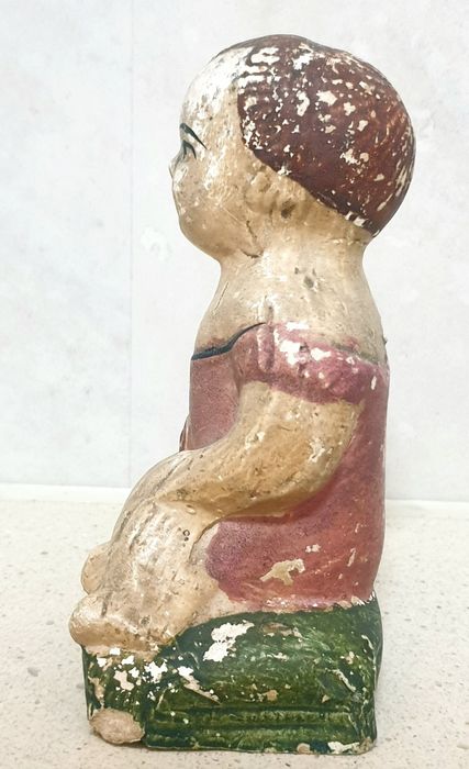 Antiga escultura de uma criança com rosas em cerâmica