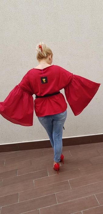 Czerwona bluzka z szerokimi rękawami.