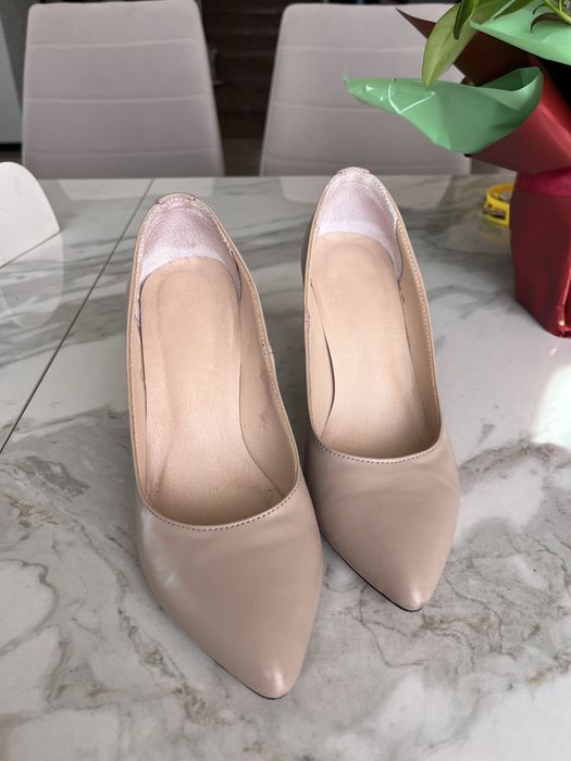 Шкіряні туфлі бежевого кольору.