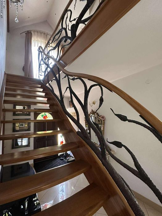 Piękne dębowe schody z kuta barierka i giętą poręczą